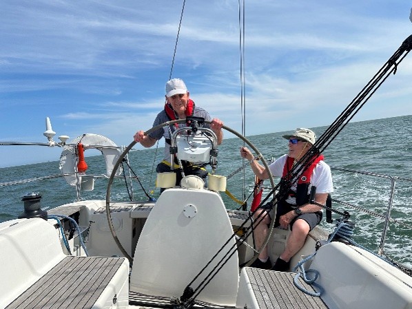 Roger, deafblind, is at the helm of his friend James’ sailing boat out in the North sea on a sunny breezy afternoon.  The boat is called Koru, one of the most important symbols of Māori traditions, representing new life, spiritual growth and progress. 
